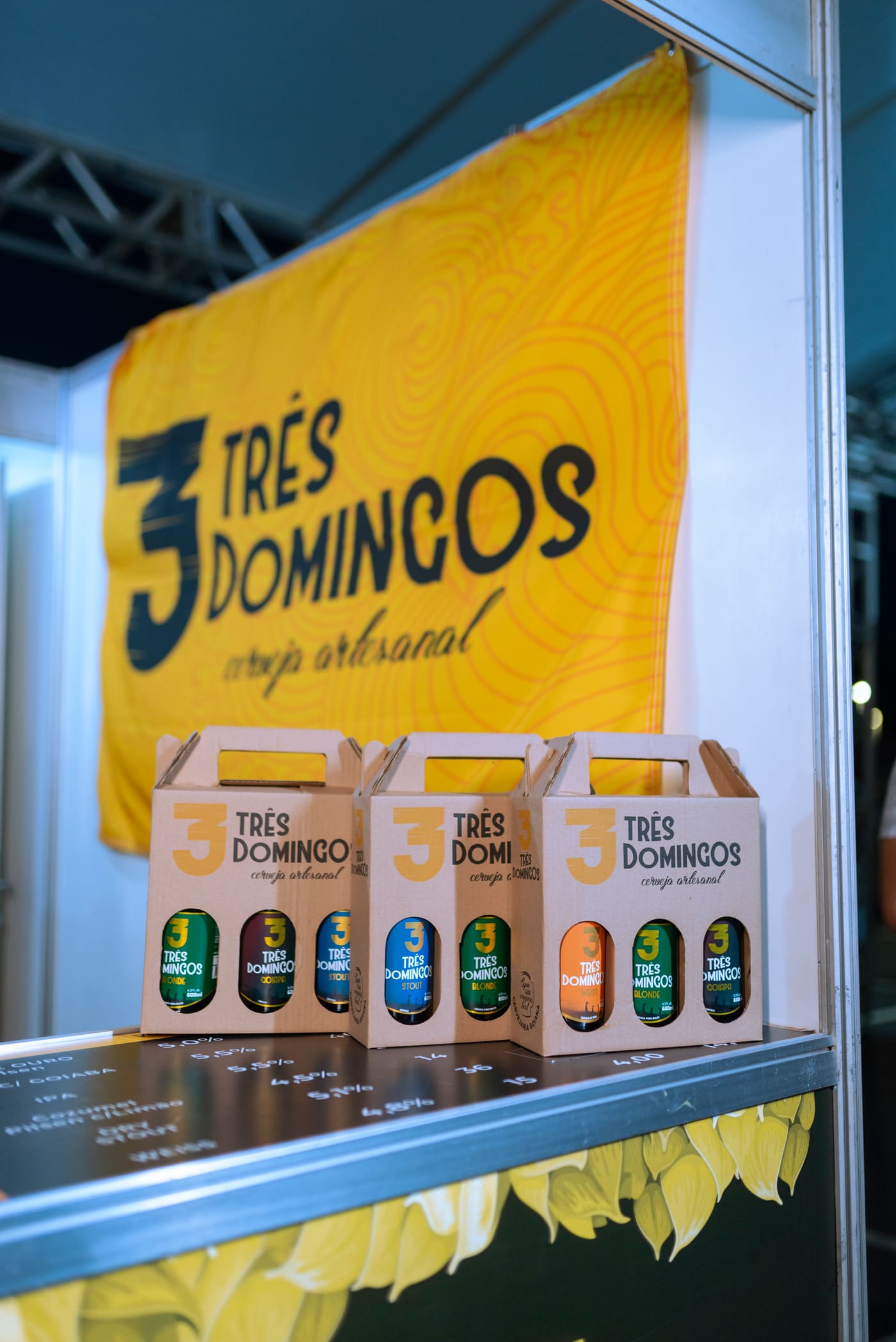 Estande da Três Domingos em festival com kits de cerveja artesanal